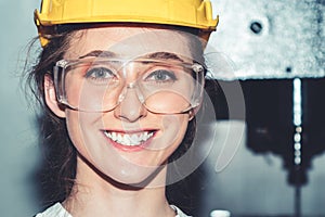 Young woman factory worker close up portrait in manufacturing job factory