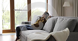 Young woman fall asleep on sofa in modern living room