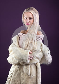 Young Woman Fashion Model dressed in white fur coat