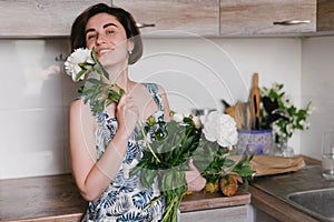 Young woman in fashon dress holding bouquet of beautiful white peonies flowers