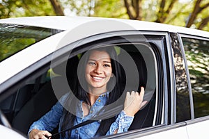 Young woman fasten seat belt in her car