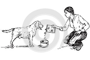 Young woman feeding dog Labrador