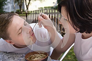 The young woman feeds her husband