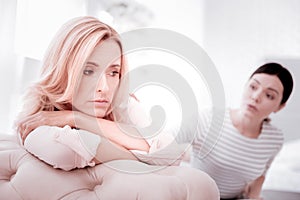 Young woman feeling awful and a skilled psychologist talking to her