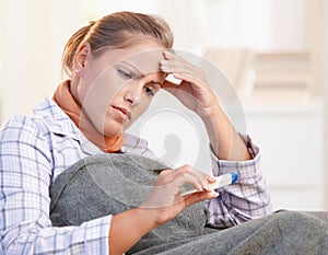 Young woman feeling bad taking her temperature