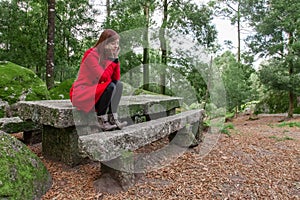 Young woman feeling depressed sitting on a forest