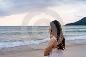 Young woman feeling lonely and sad looking at the sea on a gloomy day