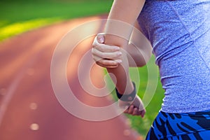 Young woman feeling pain in her elbow during sport workout at st