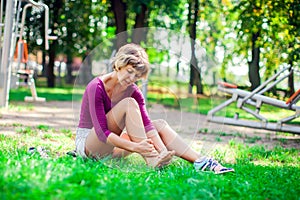 Young woman feeling pain in her foot during sport workout in the