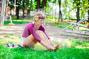 Young woman feeling pain in her foot during sport workout in the