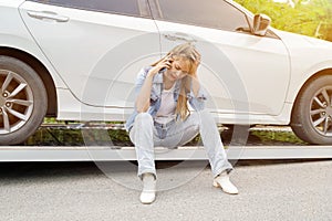 Young woman feeling sad in the damaged car after a car acciden