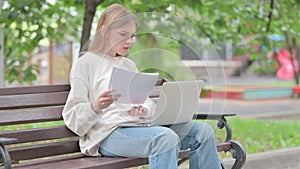 Young Woman Feeling Upset while Reading Contract and Using Laptop Outdoor