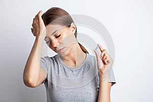 A young woman feels a headache and holds the place of pain with her hands