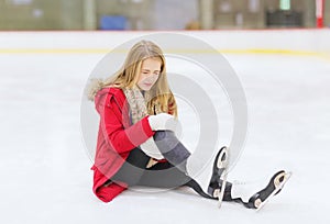 Young woman fell down on skating rink