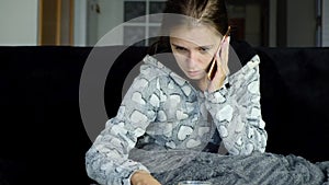 Young woman with fever calling her doctor