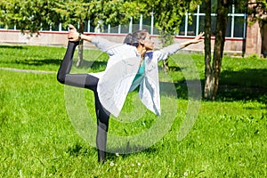 Young woman in the field, young woman doing yoga exercises in the park