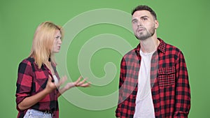 Young woman fighting young man against green background