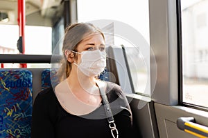 Young woman with a filtering facepiece in a bus