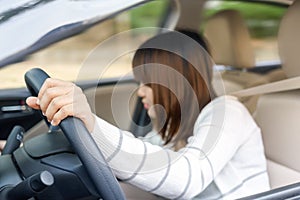 Young woman find something in drawer front of car with carelessness while driving - accident concept. photo