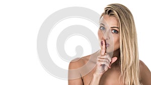 Young woman with a finger near her lips. Studio shot. Isolated on white background