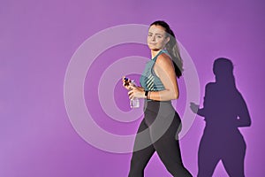 Young woman with fit body with a bottle of water.