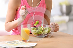 Young woman in fitness clothes having breakfast at home, closeup