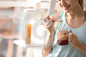 Young woman in fitness clothes having breakfast at home, closeup. Space for text