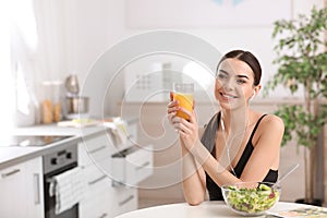 Young woman in fitness clothes having healthy breakfast