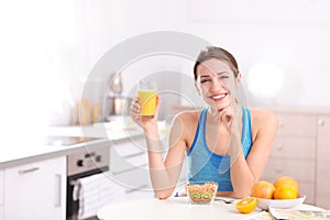 Young woman in fitness clothes having healthy breakfast