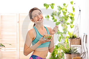 Young woman in fitness clothes having healthy breakfast