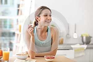 Young woman in fitness clothes having healthy breakfast