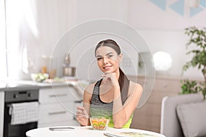 Young woman in fitness clothes having healthy breakfast