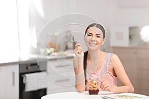 Young woman in fitness clothes having healthy breakfast at hom e