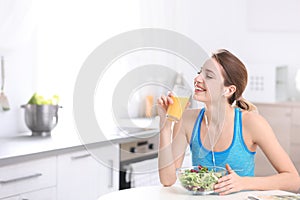 Young woman in fitness clothes having healthy breakfast at home.