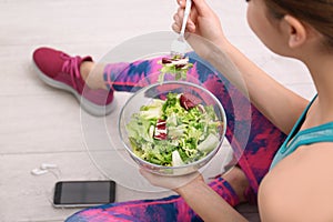 Young woman in fitness clothes having healthy breakfast at home