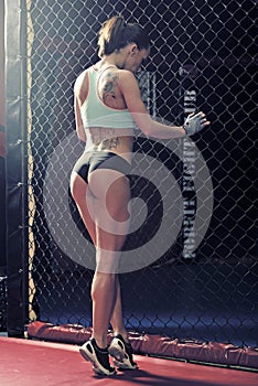 Young woman fitness in kickboxing training cage