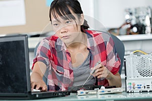 young woman fixing computer
