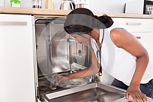 Young Woman Fixing Dishwasher
