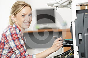 young woman fixing printer