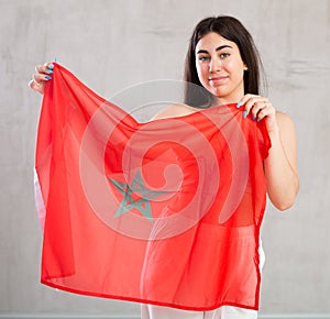Young woman with flag of Morocco posing in studio