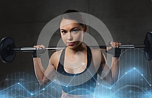 Young woman flexing muscles with barbell in gym