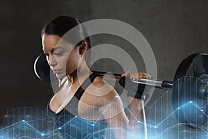 Young woman flexing muscles with barbell in gym