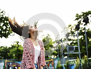 Young woman flinging her hair at an amusement park