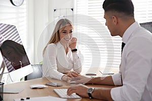 Young woman flirting with her colleague during work in office