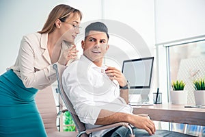 Young woman flirting with her colleague during work in office