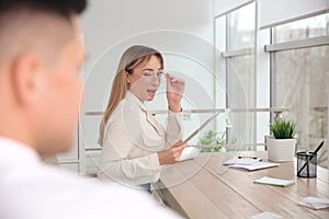 Young woman flirting with her colleague during work in office