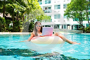 A young woman is floating on the sea in a swimming circle. A girl is relaxing on the sea on the inflatable ring with