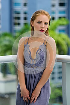 Young woman in floral spring summer dress. Girl posing on a city background. Stylish hairstyle. Fashion photo. Glamour