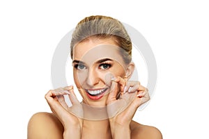 Young woman flossing her teeth.