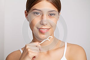 Young woman flossing her teeth in bathroom